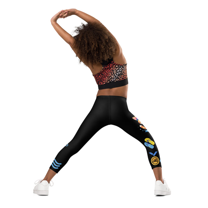 Aqua Kitty Winner Girls Leggings, black background with a blue and yellow swimmer cat wearing a diving mask and swim cap on one leg, golden medal and pool slippers below, "at the pool" text with water drop, and pool water with ladder on the other leg, back angle with relaxed pose on model