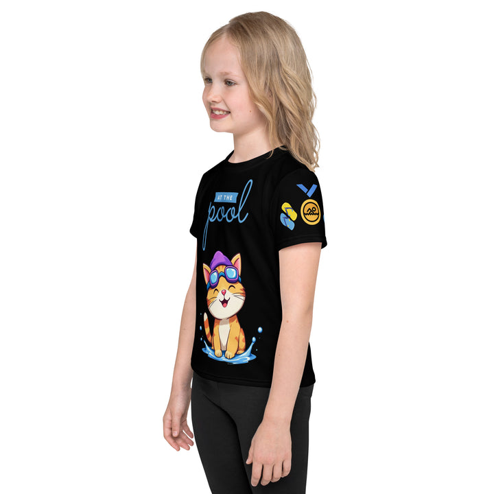 Aqua Kitty Winner Girls T-shirt, black background with a blue and yellow swimmer cat wearing diving goggles and a swim cap on the front, blue "At the pool" text above, water with drops below, golden medal and pool slippers on the left sleeve, and pool water waves with ladder on the back, left side view on model