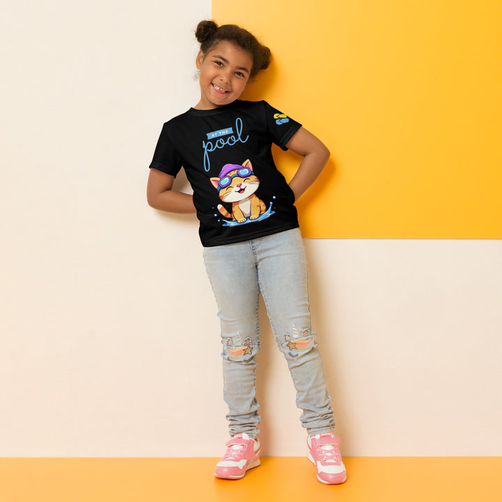  Aqua Kitty Winner Girls T-shirt, black background with a blue and yellow swimmer cat wearing diving goggles and a swim cap on the front, blue "At the pool" text above, water with drops below, golden medal and pool slippers on the left sleeve, and pool water waves with ladder on the back, relaxed front pose on model