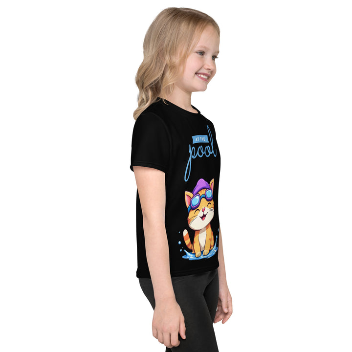 Aqua Kitty Winner Girls T-shirt, black background with a blue and yellow swimmer cat wearing diving goggles and a swim cap on the front, blue "At the pool" text above, water with drops below, golden medal and pool slippers on the left sleeve, and pool water waves with ladder on the back, right side view on model