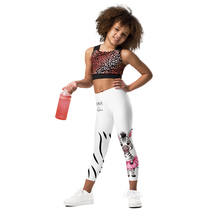 Ballet Black and White Zebra Girls Leggings, white background with a black and white zebra wearing a pink ballet skirt on the lower part of one leg, and black zebra stripes on the lower part of the other leg, relaxed front pose on model-with a visible 'Leona Fashion' text on the design