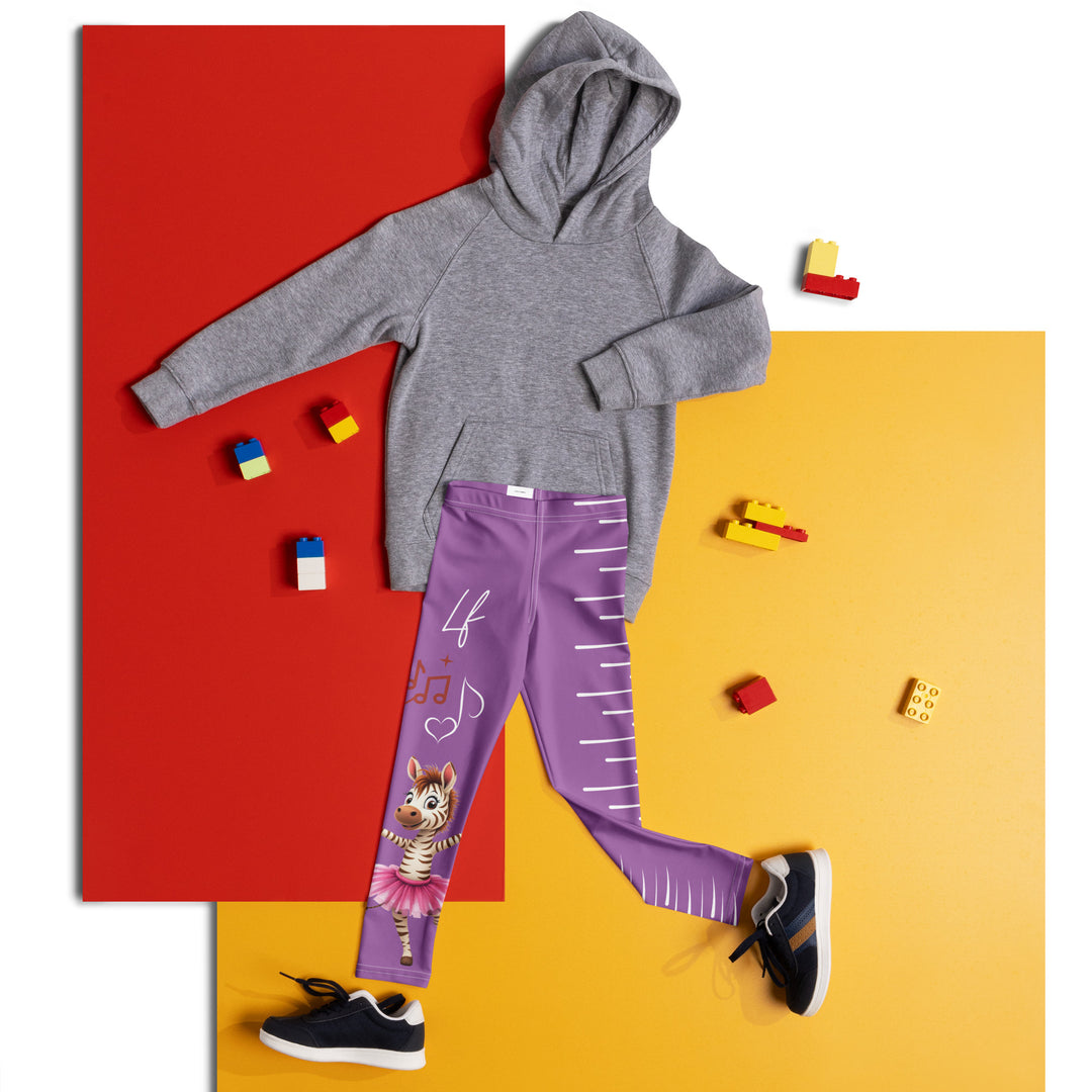 Ballet Sweet Zebra Girls Leggings, purple background with a brown and white zebra in a pink ballet skirt standing on one leg with arms extended, brown music notes above, and white vertical stripes running down the opposite leg, front view laid flat on floor
