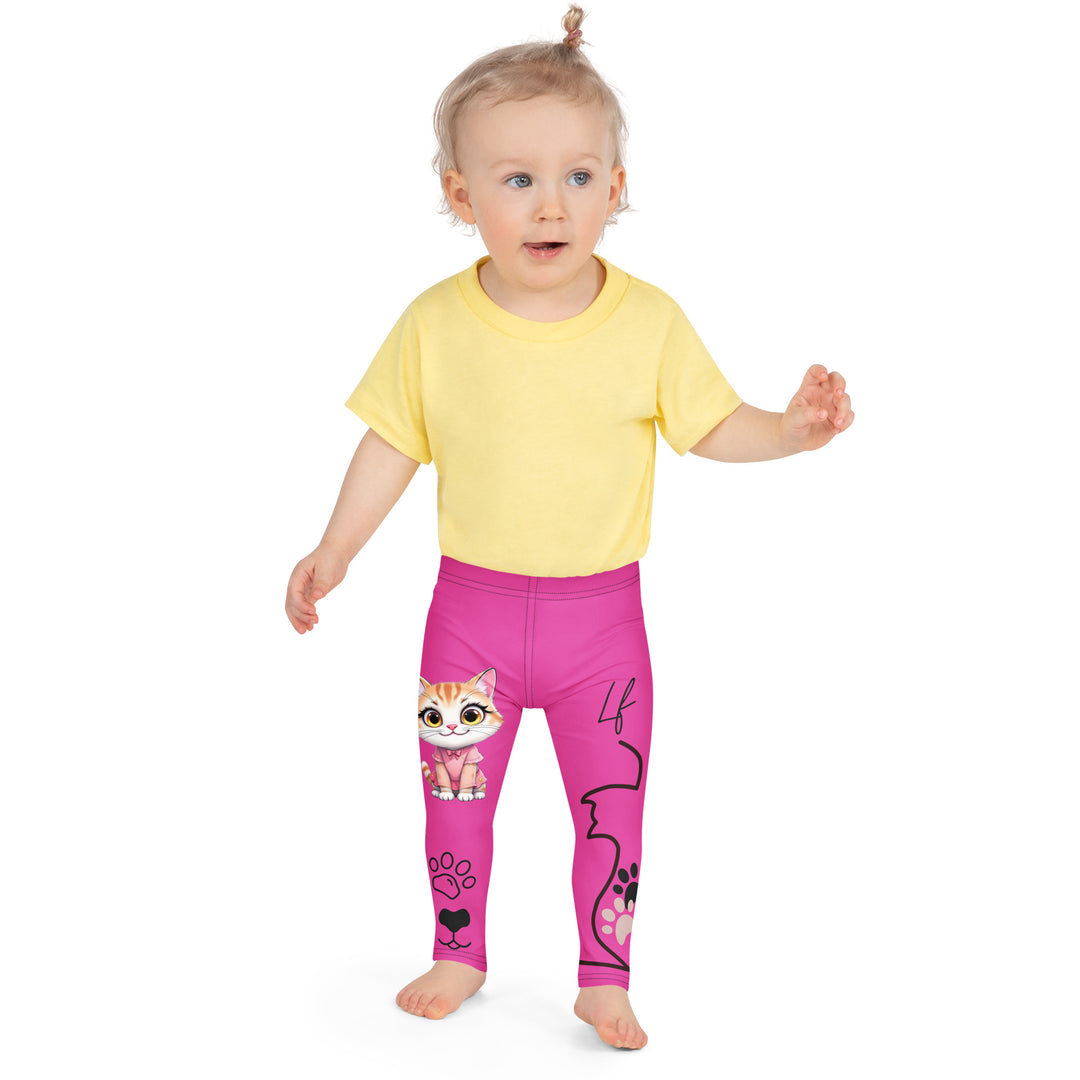 Cat Trace Girls Leggings, pink background with a yellow cat wearing a pink dress at the top of one leg, black paw prints and a black cat nose below, and a black line-drawn cat with black and cream paw prints on the other leg, front close-up view on model