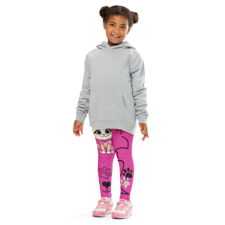 Cat Trace Girls Leggings, pink background with a yellow cat wearing a pink dress at the top of one leg, black paw prints and a black cat nose below, and a black line-drawn cat with black and cream paw prints on the other leg, front pose with arms at sides on model