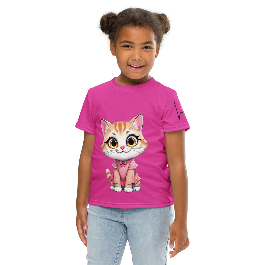 Cat Trace Girls T-shirt, pink background with a yellow cat sitting and wearing a light pink dress, with big eyes, long eyelashes, and a smiling expression on the front, and a black line-drawn cat with one black paw and one cream paw on the left sleeve, relaxed front pose on model