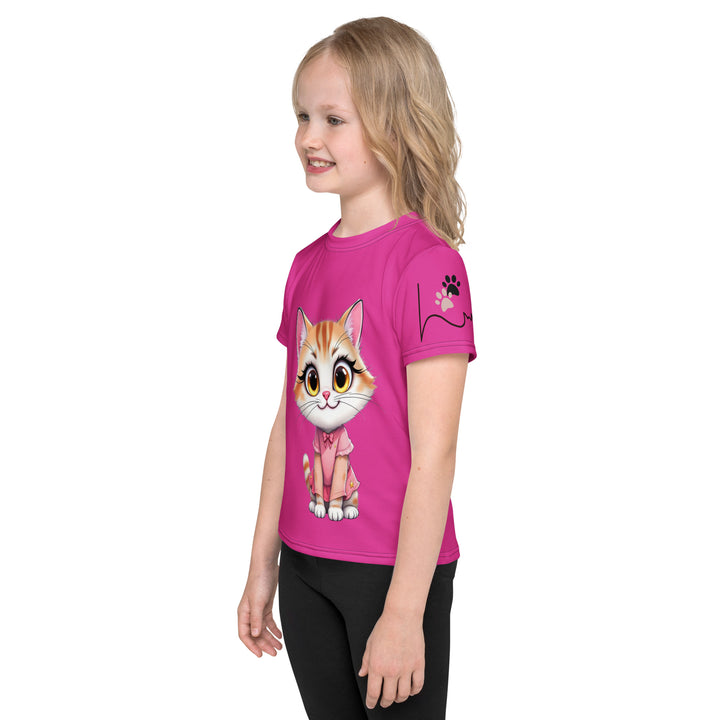 Cat Trace Girls T-shirt, pink background with a yellow cat sitting and wearing a light pink dress, with big eyes, long eyelashes, and a smiling expression on the front, and a black line-drawn cat with one black paw and one cream paw on the left sleeve, left side view on model