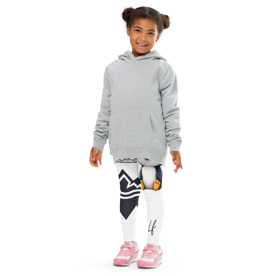 Chilly Penguin Girls Leggings, white background with a black and white small penguin sitting with green eyes on one leg, and a black and white iceberg with a wooden snow sign that says "NORTH POLE" on the other leg, front pose with arms at sides on model