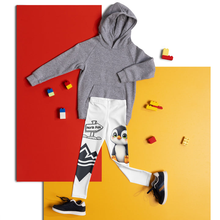  Chilly Penguin Girls Leggings, white background with a black and white small penguin sitting with green eyes on one leg, and a black and white iceberg with a wooden snow sign that says "NORTH POLE" on the other leg, front view laid flat on floor