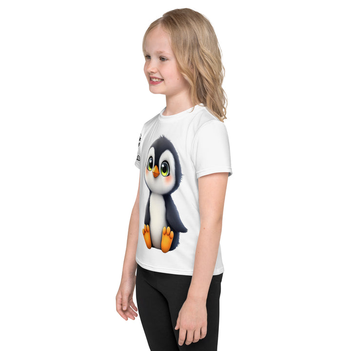 Chilly Penguin Girls T-shirt, white background with a black and white baby penguin sitting with green eyes on the front, a black line snow sign with "NORTH POLE" text on the left sleeve, and a black and white iceberg on the back, left side view on model