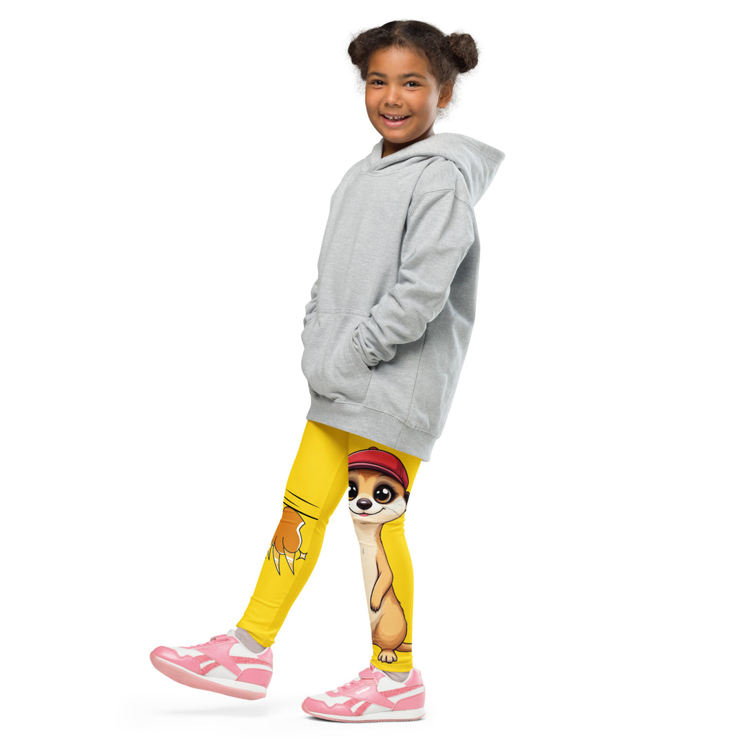 Cool Meerkat Girls Leggings, yellow background with a meerkat wearing a red cap on one leg and a paw graphic on the other leg appearing to come through the fabric, front view with one leg lifted and extended on model