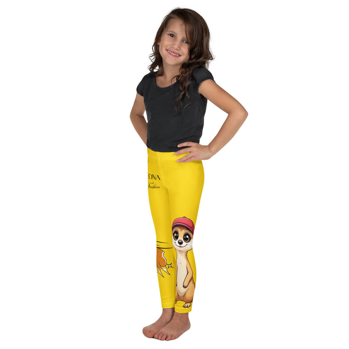  Cool Meerkat Girls Leggings, yellow background with a meerkat wearing a red cap on one leg and a paw graphic on the other leg appearing to come through the fabric, left side view on model-with a visible 'Leona Fashion' text on the design