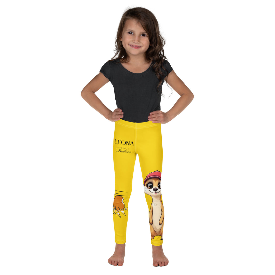  Cool Meerkat Girls Leggings, yellow background with a meerkat wearing a red cap on one leg and a paw graphic on the other leg appearing to come through the fabric, relaxed front pose on model-with a visible 'Leona Fashion' text on the design