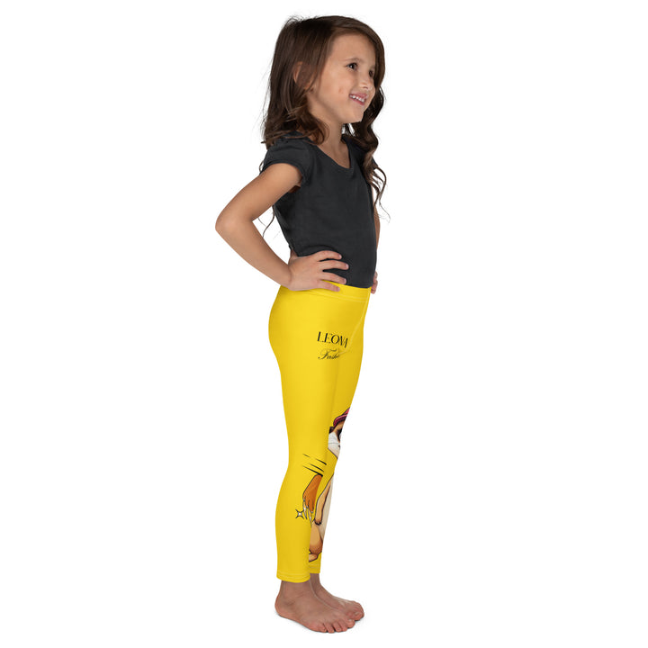 Cool Meerkat Girls Leggings, yellow background with a meerkat wearing a red cap on one leg and a paw graphic on the other leg appearing to come through the fabric, right side view on model-with a visible 'Leona Fashion' text on the design