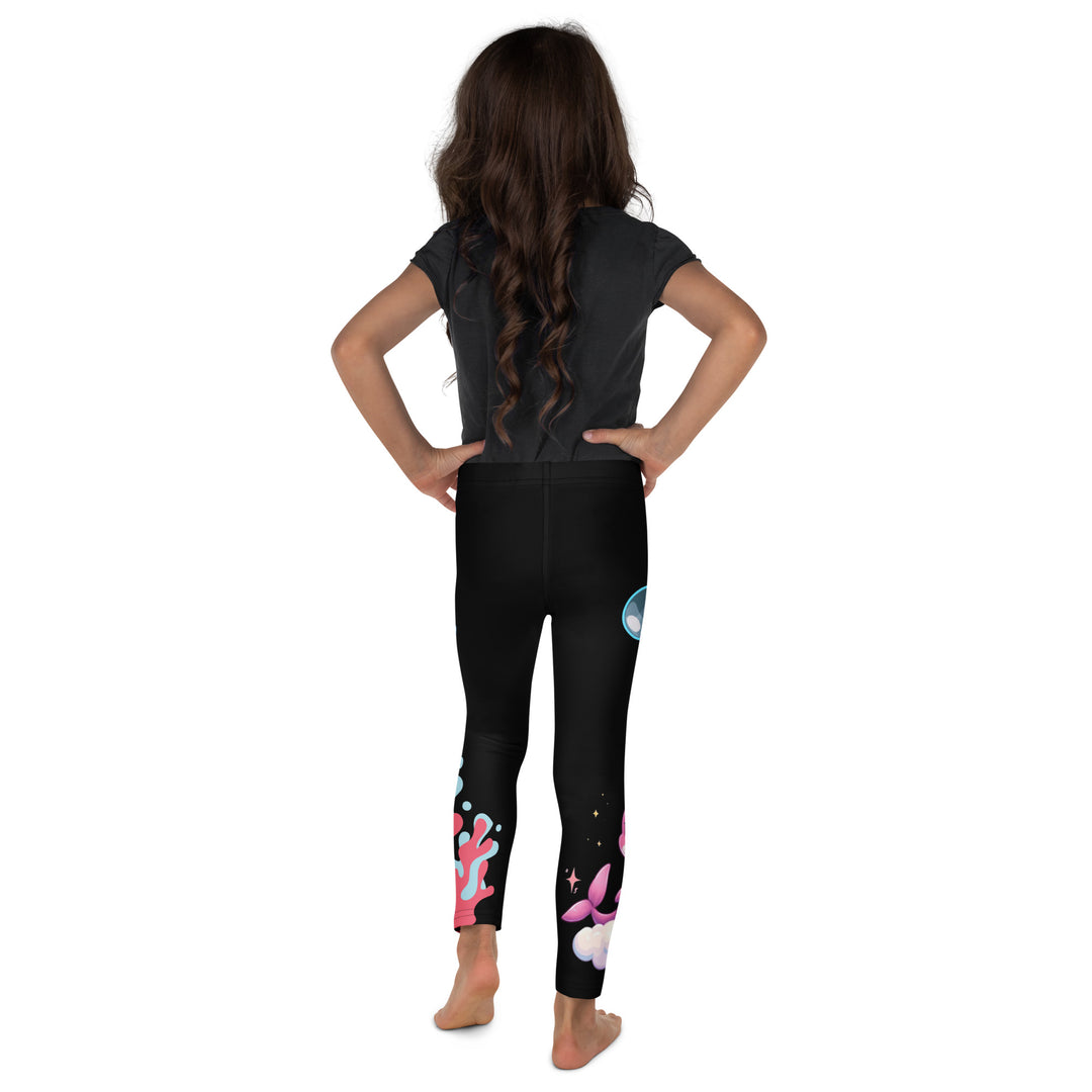 Coral Dolphin Girls Leggings, black background with a pink baby dolphin lying on a white cloud at the bottom of one leg and blue sea bubbles above, and a blue baby dolphin on the upper part of the other leg with pink and blue coral details at the bottom, back view on model
