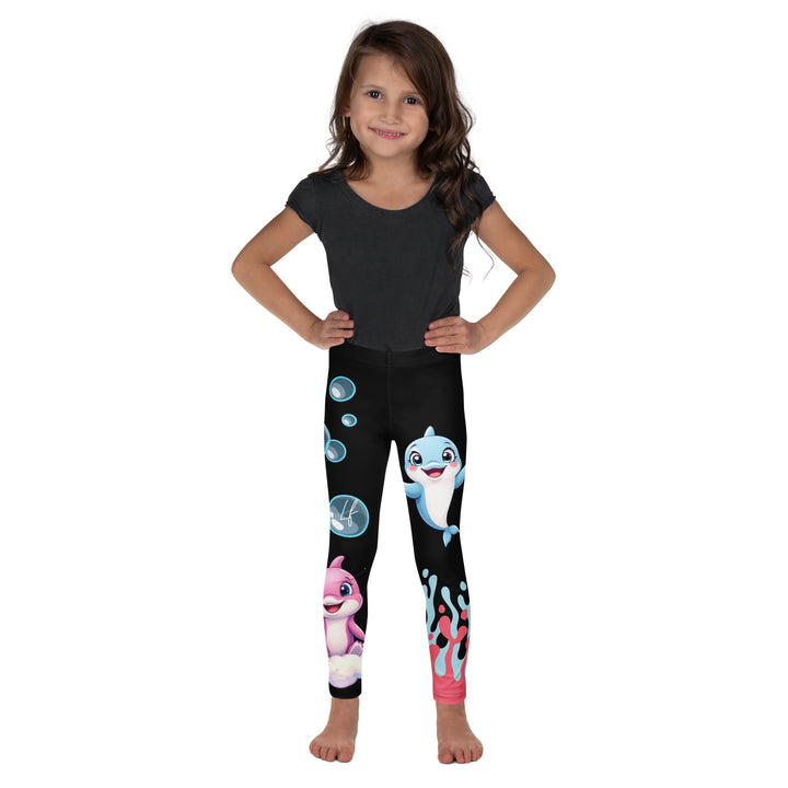  Coral Dolphin Girls Leggings, black background with a pink baby dolphin lying on a white cloud at the bottom of one leg and blue sea bubbles above, and a blue baby dolphin on the upper part of the other leg with pink and blue coral details at the bottom, front view on model