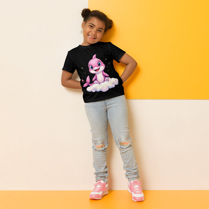 Coral Dolphin Girls T-shirt, black background with a pink baby dolphin sitting on a white cloud surrounded by small sparkling yellow stars, relaxed front pose on model