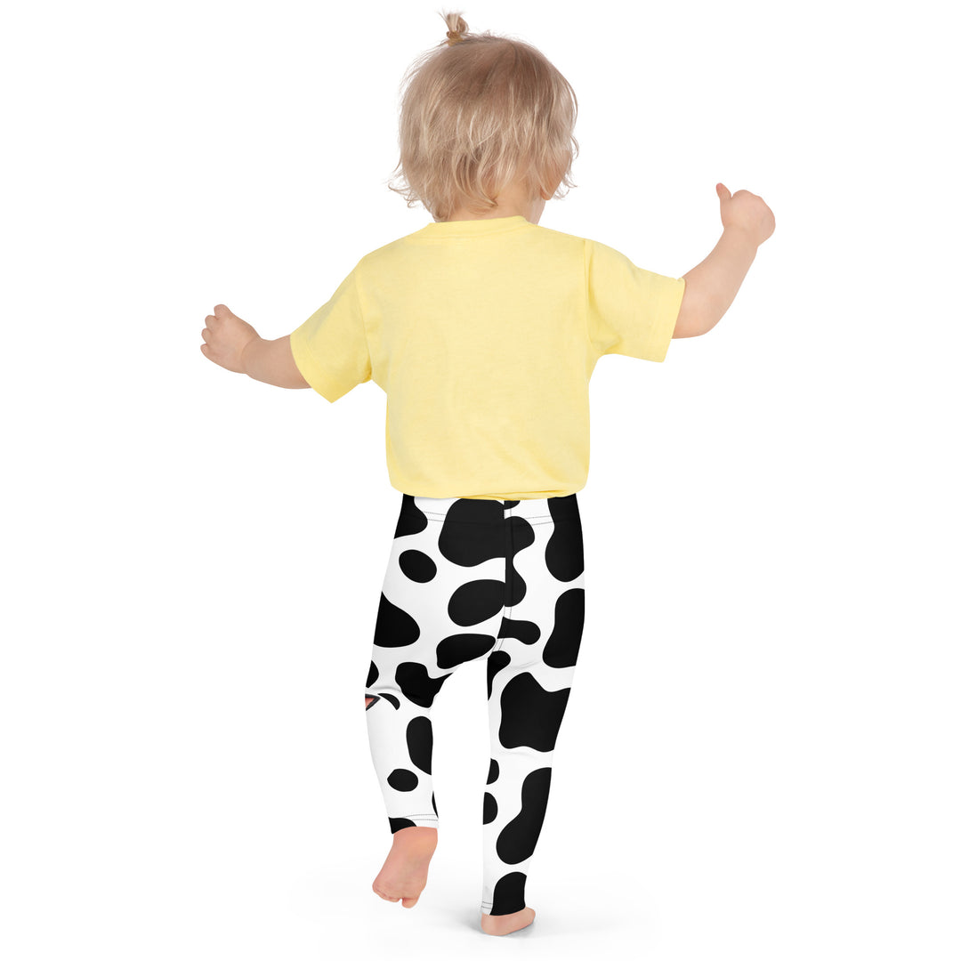 Cowlicious Love Girls Leggings, white background with black cow-like spots and a small black and white cow with a flower in its hair on one leg, back pose on model