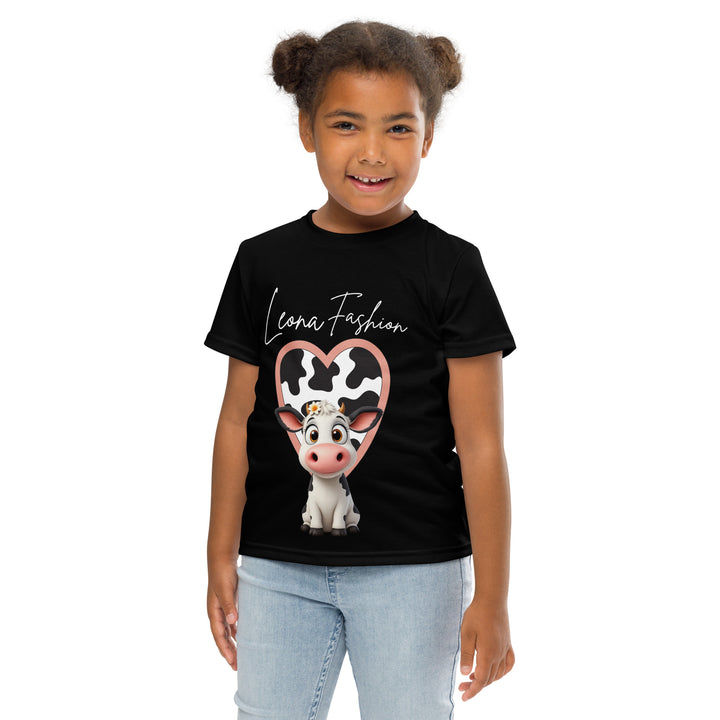 Cowlicious Love Girls T-shirt, black background with a black and white cow featuring a flower in its hair on the front, and a black and white cow-print heart outlined in pink behind it, front pose with arms at sides on model-with a visible 'Leona Fashion' text on the design
