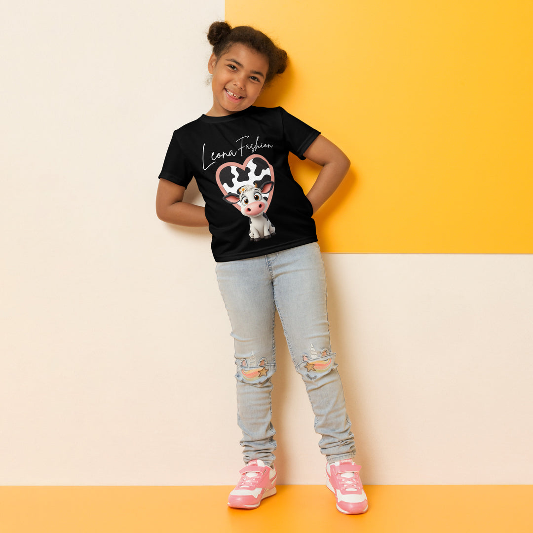 Cowlicious Love Girls T-shirt, black background with a black and white cow featuring a flower in its hair on the front, and a black and white cow-print heart outlined in pink behind it, relaxed front pose on model-with a visible 'Leona Fashion' text on the design