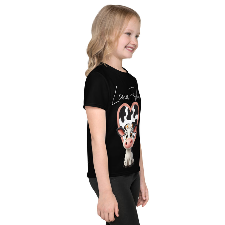 Cowlicious Love Girls T-shirt, black background with a black and white cow featuring a flower in its hair on the front, and a black and white cow-print heart outlined in pink behind it, right side view on model-with a visible 'Leona Fashion' text on the design