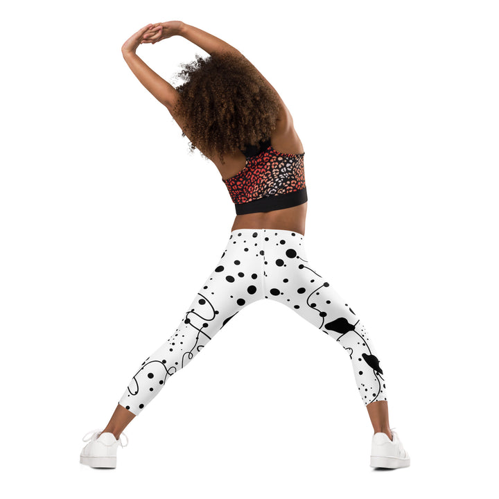 Dot & Line Girls Leggings, white background with black spots, lines, and dots interwoven throughout the design, back angle with relaxed pose on model