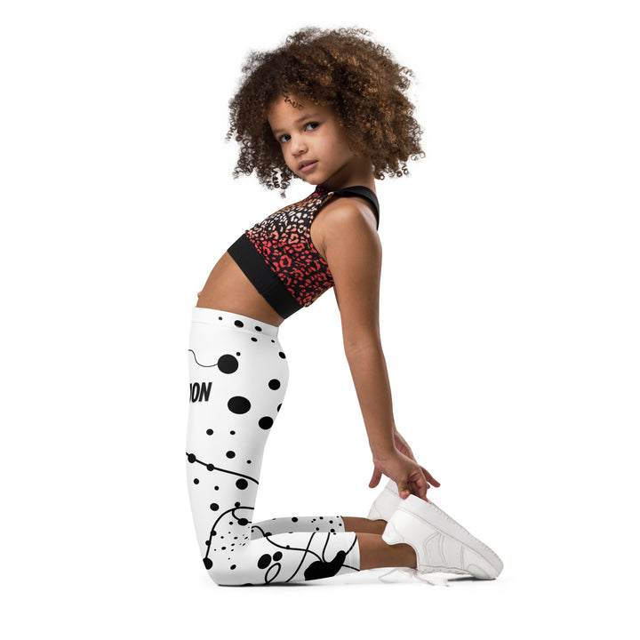  Dot & Line Girls Leggings, white background with black spots, lines, and dots interwoven throughout the design, left side view kneeling on model