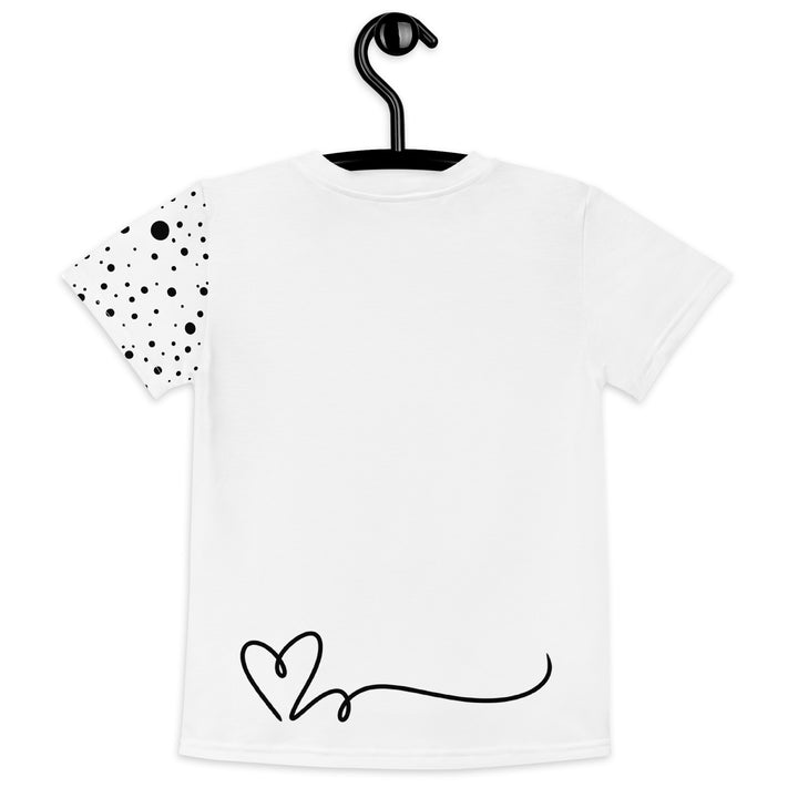 Dot & Line Girls T-shirt, white background with black spots, lines, and a heart on the front, black dots on the left sleeve, and a black heart with a line detail near the bottom on the back, back view on hanger