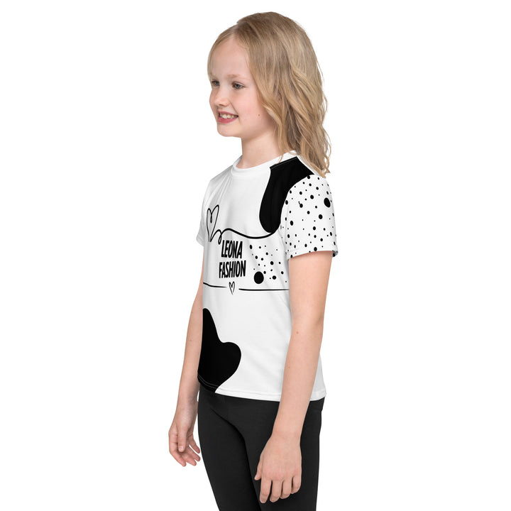Dot & Line Girls T-shirt, white background with black spots, lines, and a heart on the front, black dots on the left sleeve, and a black heart with a line detail near the bottom on the back, left side view on model-with a visible 'Leona Fashion' text on the design