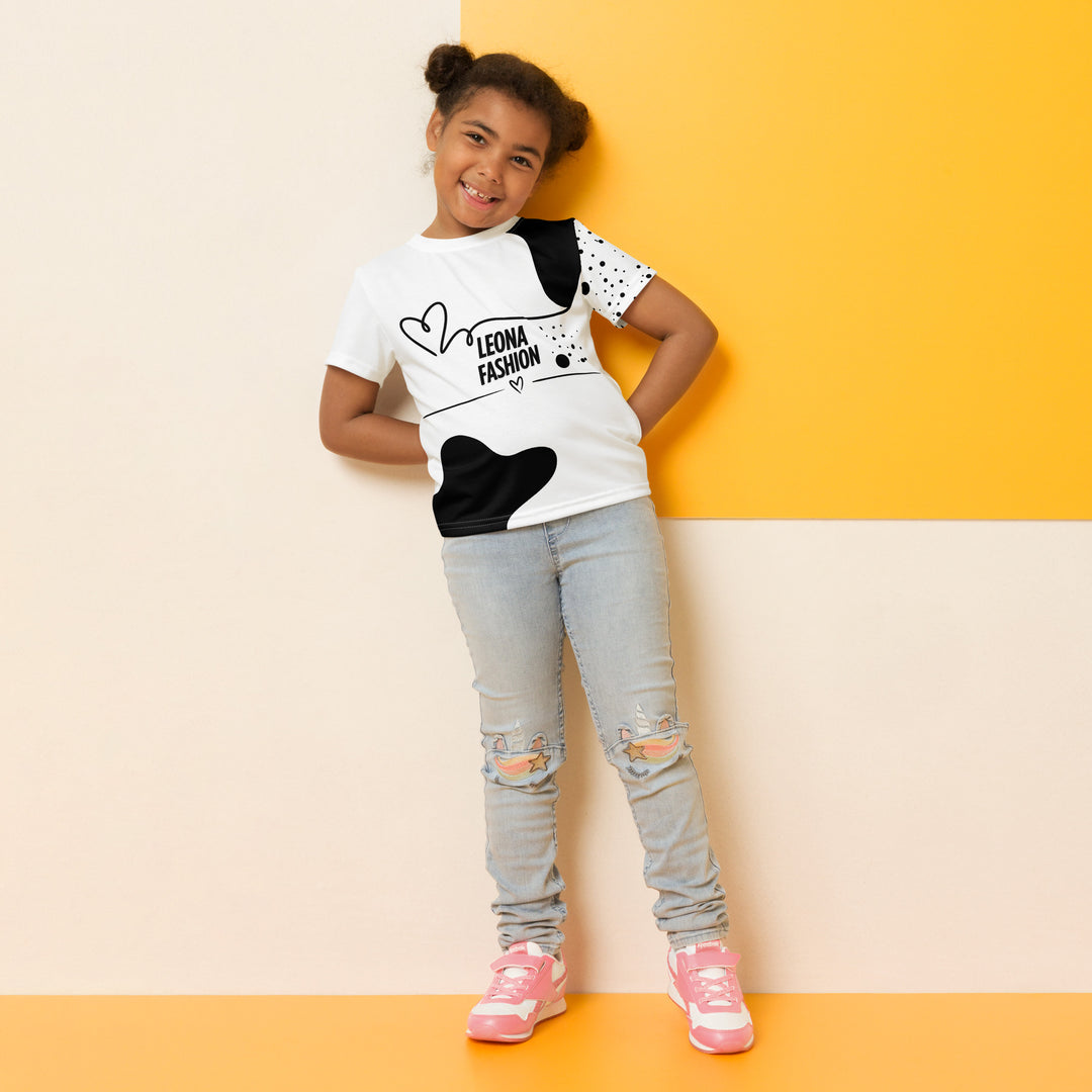 Dot & Line Girls T-shirt, white background with black spots, lines, and a heart on the front, black dots on the left sleeve, and a black heart with a line detail near the bottom on the back, relaxed front pose on model-with a visible 'Leona Fashion' text on the design