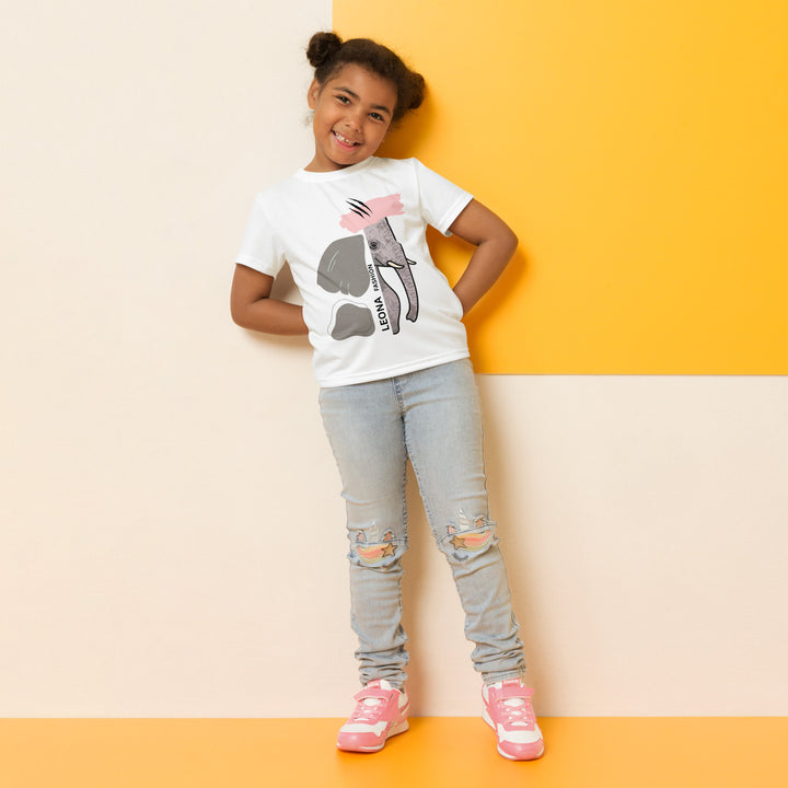 Elephant Whispers Girls T-shirt, white background with gray elephant in profile on one side, visible trunk, and soft blush pink stripe detail across the head, relaxed front pose on model-with a visible 'Leona Fashion' text on the design