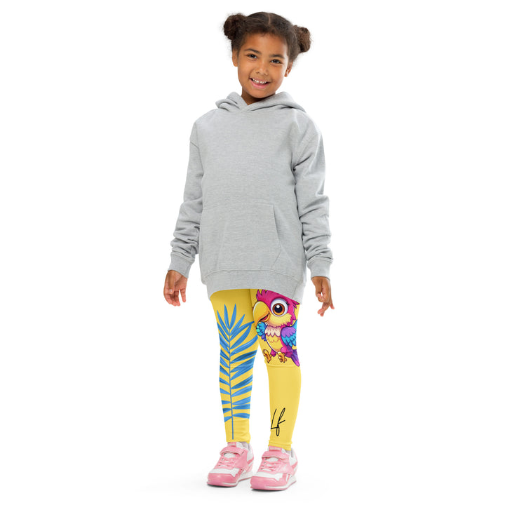  Fly Baby Parrot Girls Leggings, yellow background with a small pink baby parrot with spread wings on one leg, and a large blue tropical leaf with "I CAN DO IT" text in blue and pink letters above it on the other leg, front pose with arms at sides on model