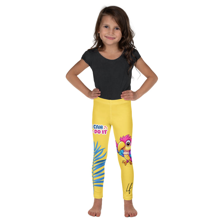 Fly Baby Parrot Girls Leggings, yellow background with a small pink baby parrot with spread wings on one leg, and a large blue tropical leaf with "I CAN DO IT" text in blue and pink letters above it on the other leg, front view on model