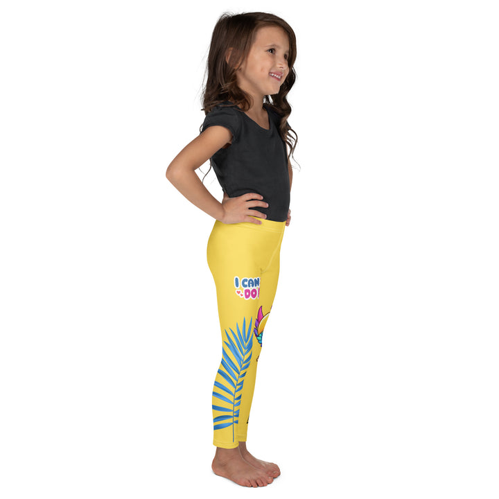Fly Baby Parrot Girls Leggings, yellow background with a small pink baby parrot with spread wings on one leg, and a large blue tropical leaf with "I CAN DO IT" text in blue and pink letters above it on the other leg, right side view on model