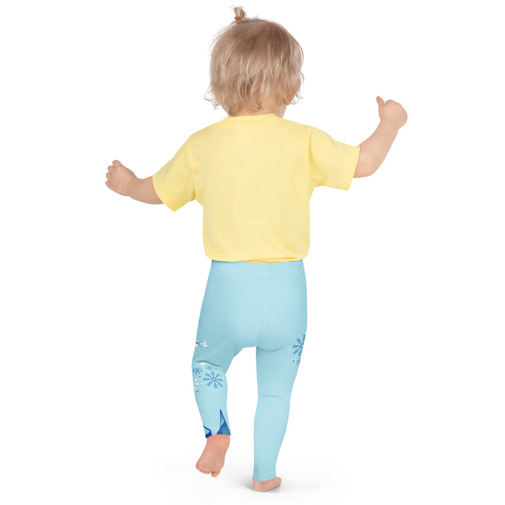  Frosty Seal Girls Leggings, light sky blue background with a white baby seal, blue and white snowflakes, and an ice block on one leg, and blue and white ice cubes with snowflakes on the other leg, back angle with relaxed pose on model