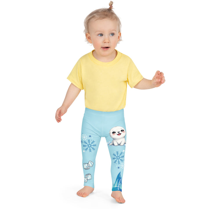  Frosty Seal Girls Leggings, light sky blue background with a white baby seal, blue and white snowflakes, and an ice block on one leg, and blue and white ice cubes with snowflakes on the other leg, front close-up view on model