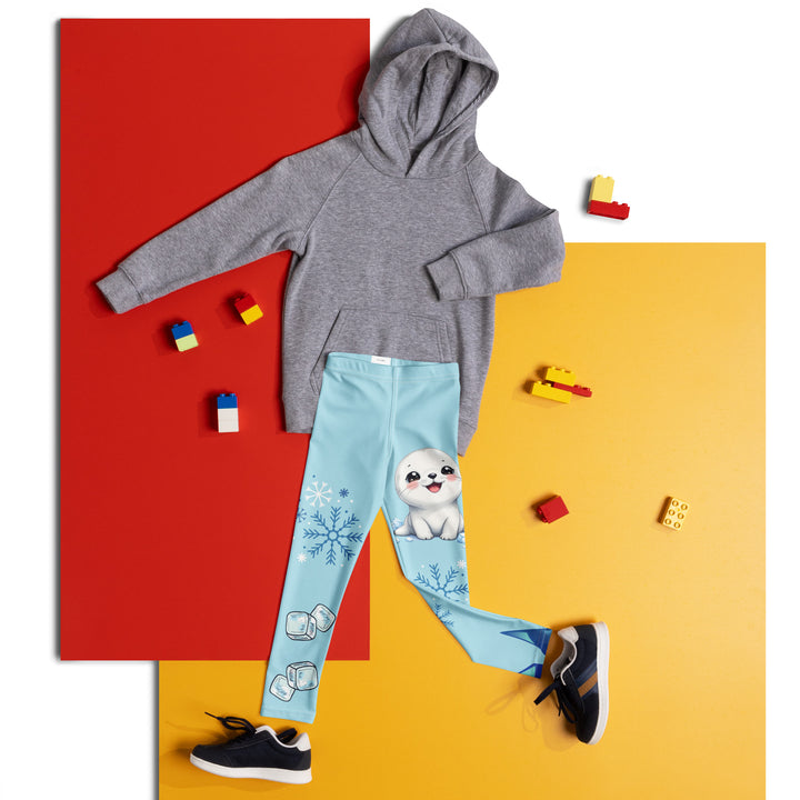 Frosty Seal Girls Leggings, light sky blue background with a white baby seal, blue and white snowflakes, and an ice block on one leg, and blue and white ice cubes with snowflakes on the other leg, front view laid flat on floor
