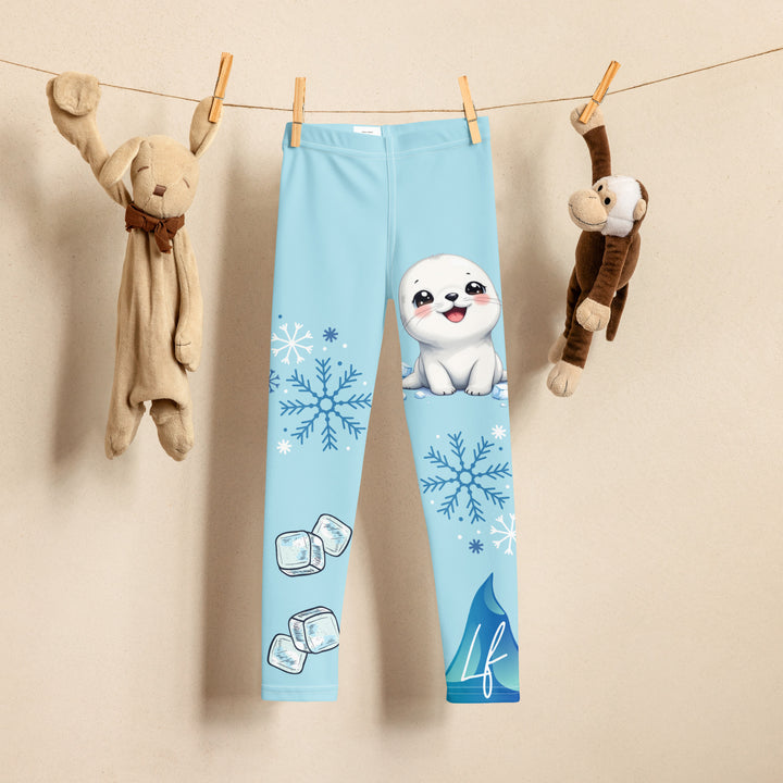  Frosty Seal Girls Leggings, light sky blue background with a white baby seal, blue and white snowflakes, and an ice block on one leg, and blue and white ice cubes with snowflakes on the other leg, front view on hanger
