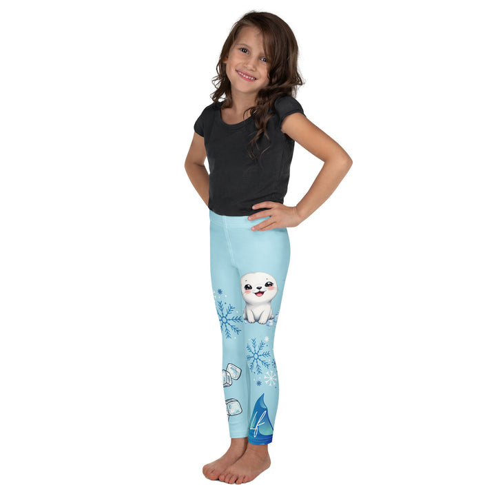  Frosty Seal Girls Leggings, light sky blue background with a white baby seal, blue and white snowflakes, and an ice block on one leg, and blue and white ice cubes with snowflakes on the other leg, left side view on model