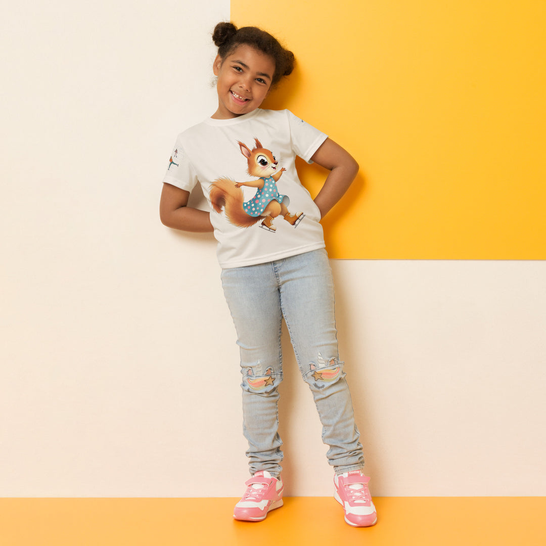 Frosty Twirl Squirrel Girls T-shirt, beige background with a brown squirrel ice skating in a blue polka dot dress on the front, ice trail lines on the sleeves, mountains and ice skaters on the back, in blue, brown, and orange tones, relaxed front pose on model
