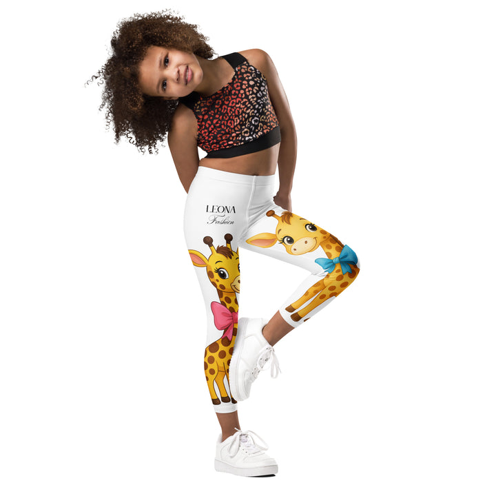  Giraffe Love Girls Leggings, white background with a full-length girl giraffe wearing a big pink bow around her neck on one leg, and a full-length boy giraffe with a blue bow around his neck on the other leg, side view with one leg lifted and bent on model