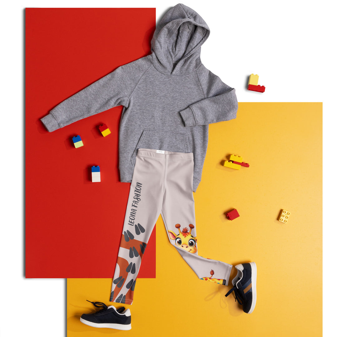 Giraffe Path Girls Leggings, cream background with a yellow giraffe featuring colorful polka dots on one leg, and orange-brown spots with dark gray giraffe footprints on the other leg, both designs starting from above the knee down, front view laid flat on floor-with a visible 'Leona Fashion' text on the design