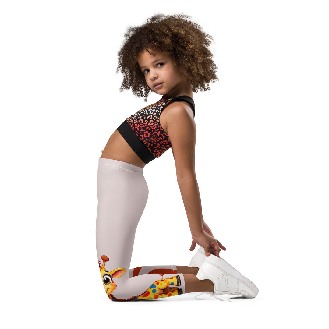 Giraffe Path Girls Leggings, cream background with a yellow giraffe featuring colorful polka dots on one leg, and orange-brown spots with dark gray giraffe footprints on the other leg, both designs starting from above the knee down, left side view kneeling on model