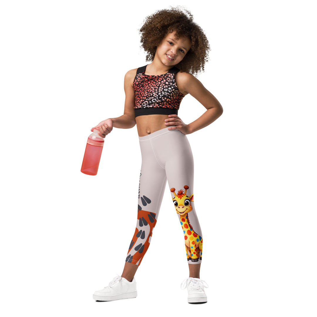Giraffe Path Girls Leggings, cream background with a yellow giraffe featuring colorful polka dots on one leg, and orange-brown spots with dark gray giraffe footprints on the other leg, both designs starting from above the knee down, relaxed front pose on model