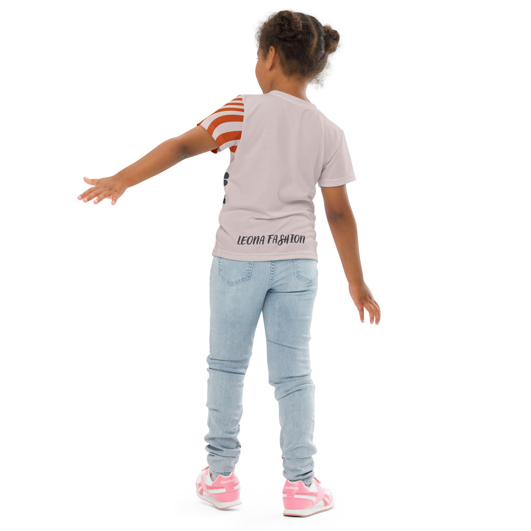 Giraffe Path Girls T-shirt, cream background with a smiling yellow giraffe featuring colorful polka dots on the front, dark gray giraffe paw prints behind, and brown-orange wavy lines on the left sleeve, back pose on model-with a visible 'Leona Fashion' text on the design