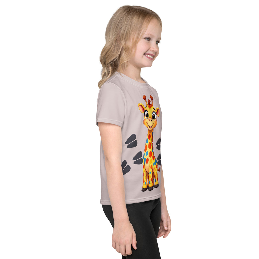 Giraffe Path Girls T-shirt, cream background with a smiling yellow giraffe featuring colorful polka dots on the front, dark gray giraffe paw prints behind, and brown-orange wavy lines on the left sleeve, right side view on model