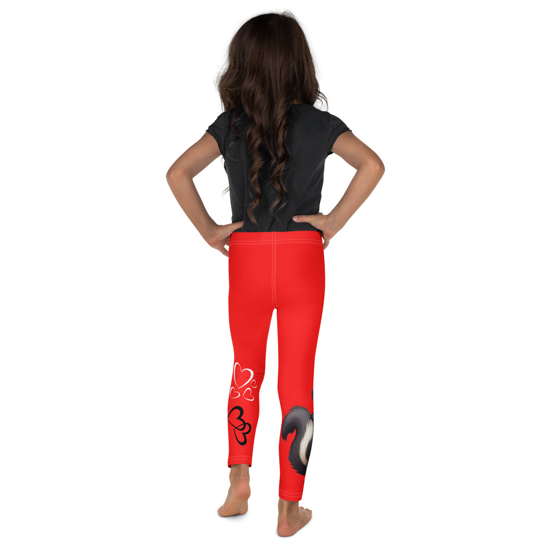 Heart Stinker Girls Leggings, red background with a black and white skunk holding a white flower in its hand, featuring white hearts and pink-and-white floral elements, back view on model