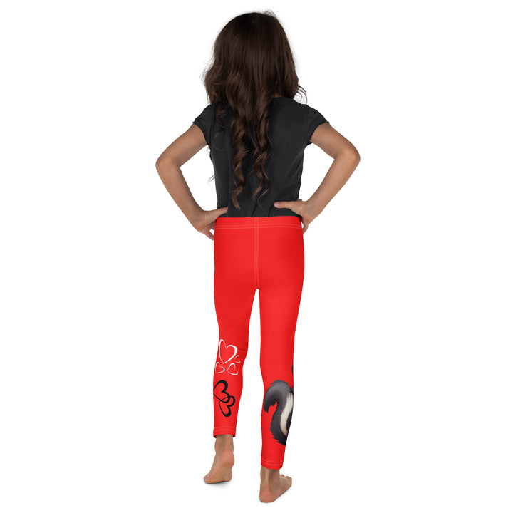 Heart Stinker Girls Leggings, red background with a black and white skunk holding a white flower in its hand, featuring white hearts and pink-and-white floral elements, back view on model