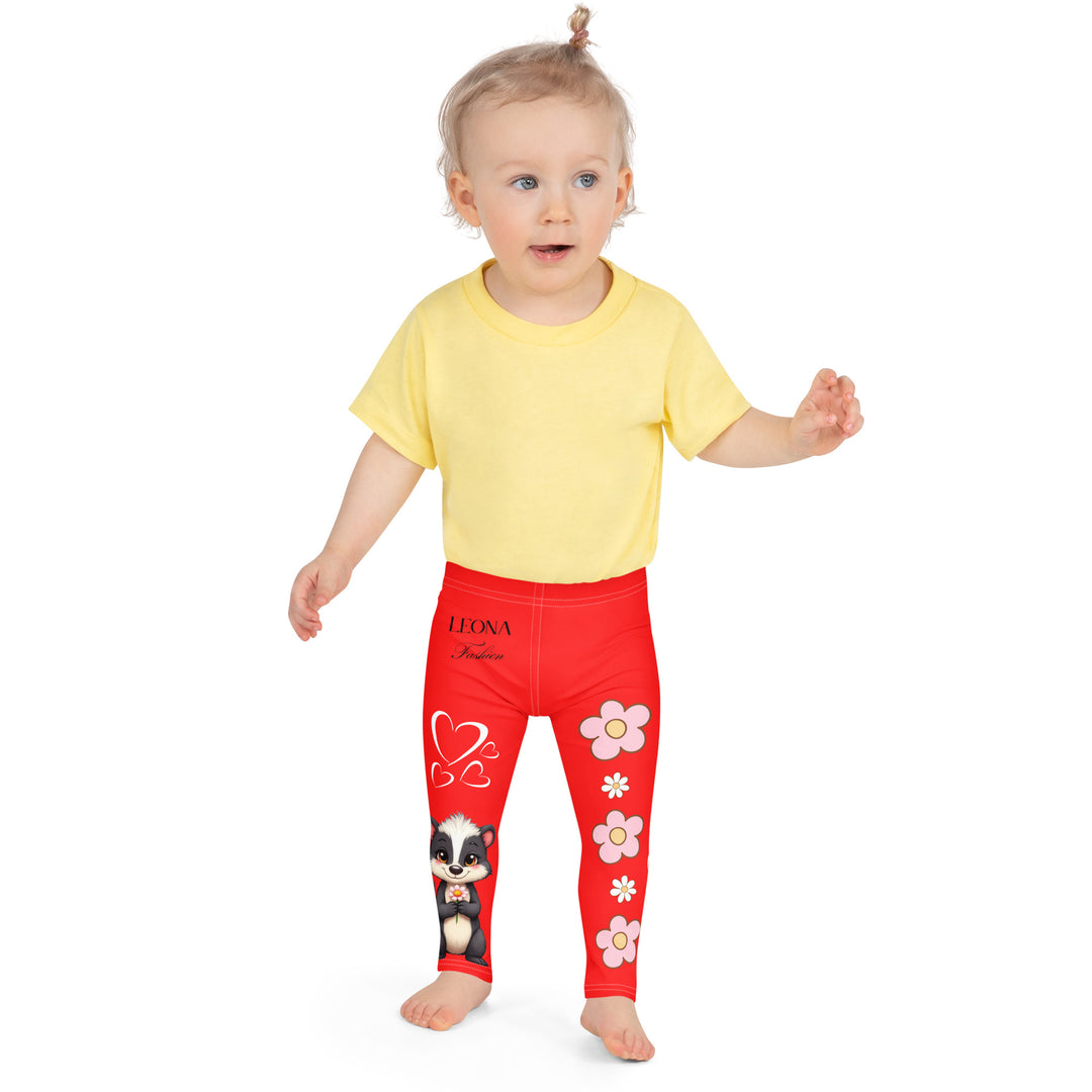 Heart Stinker Girls Leggings, red background with a black and white skunk holding a white flower in its hand, featuring white hearts and pink-and-white floral elements, front close-up view on model-with a visible 'Leona Fashion' text on the design