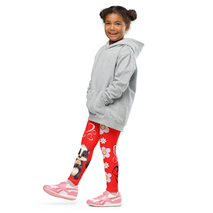 Heart Stinker Girls Leggings, red background with a black and white skunk holding a white flower in its hand, featuring white hearts and pink-and-white floral elements, front view with one leg lifted and extended on model