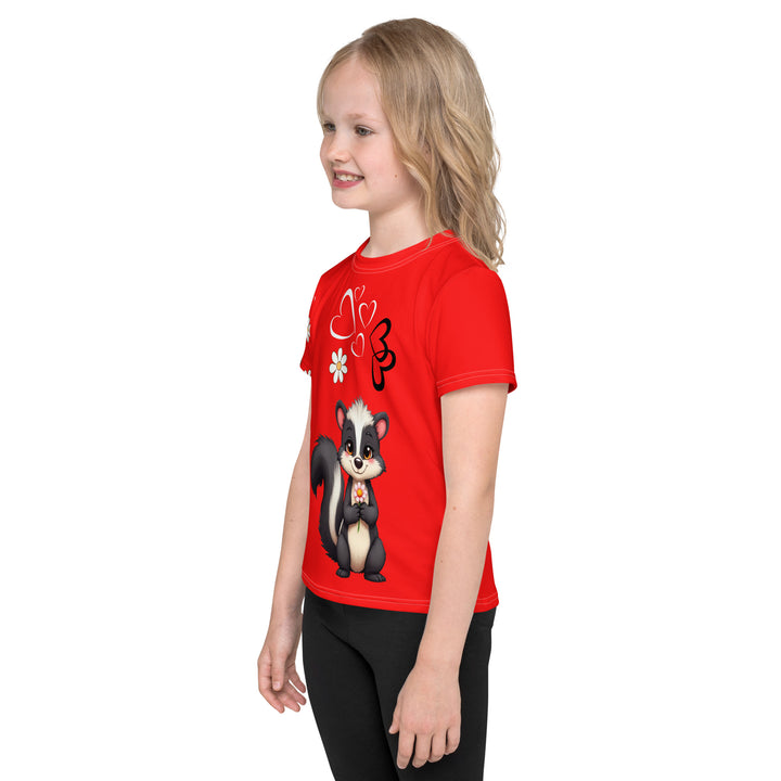 Heart Stinker Girls T-shirt, red background with a black and white skunk holding a white flower in its hand, black and white hearts and a white flower above, and pink-and-white floral details on the right sleeve, left side view on model